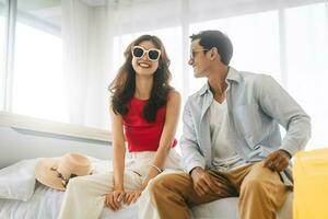 Young adult southeast asian couple traveler wear sunglasses at home in bedroom on day photo