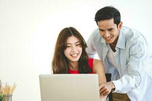 Focus on woman young adult southeast asian couple using laptop getting ready for honeymoon travel trip photo