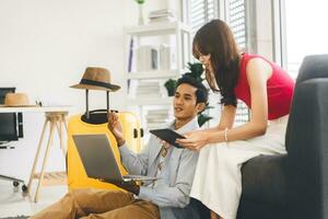 Happy smile young adult southeast asian couple using laptop for getting ready for holidays travel trip photo