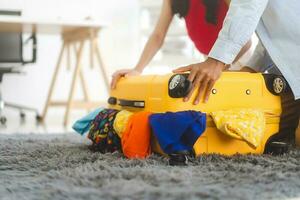 Couple hand place on full of cloth luggage with for getting ready for holidays travel trip photo