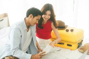 Young adult southeast asian couple using maps for getting ready for holidays travel trip photo