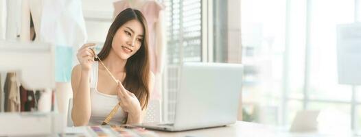 Asian woman designer job using laptop computer for online social media marketing banner size background photo