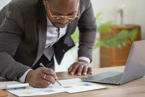 An African American businessman in a black suit smiling and showing joy at the company's annual profit to build confidence for customers who will invest in the office. photo