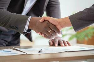 Satisfied black client shaking hands, thanking the manager for good financial deal African American businessmen shaking hands after successful business negotiations. Hiring. Buying services. photo
