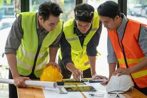 asiático ingenieros idea genial y medida a documento costo estimados y escribir piso planes para arquitectónico y Ingenieria diseños para casas y edificios foto