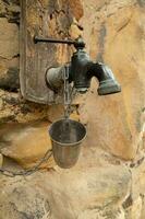 an old faucet on a stone wall photo