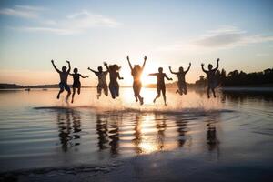 Young group of people jumping into the air at beach. photo