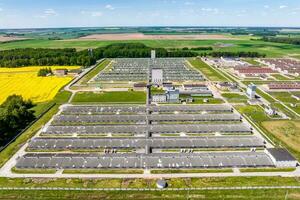 aerial panoramic view over silos and rows of barns, pigsties, chicken coops of huge agro-industrial livestock complex photo