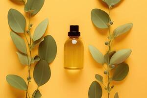 Essential oil bottle mockup and eucalyptus leaves on a yellow background. photo