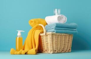 Towels, shampoo and soap in a basket against blue wall. photo