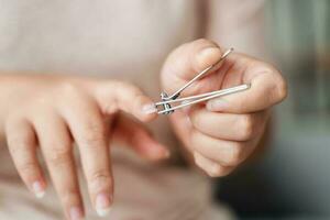 mujer corte las uñas utilizando uña clíper, cuidado de la salud, belleza concepto. foto