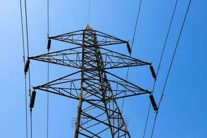 A power line tower with a blue sky in the background photo