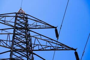 A power line tower with a blue sky in the background photo