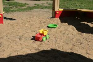 Plastic toys in the sandbox at the playground. Car, saucer photo