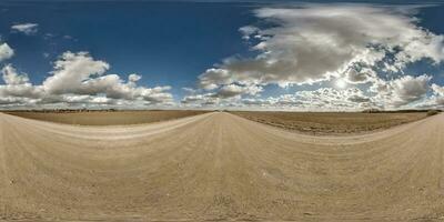 spherical 360 hdri panorama on gravel road with clouds and sun on blue sky in equirectangular seamless projection, use as sky replacement in drone panoramas, game development as sky dome or VR content photo