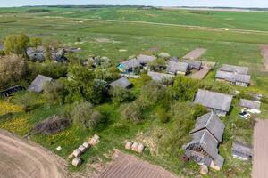 panoramic aerial view of eco village with wooden houses, gravel road, gardens and orchards photo