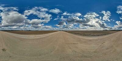 spherical 360 hdri panorama on gravel road with clouds and sun on blue sky in equirectangular seamless projection, use as sky replacement in drone panoramas, game development as sky dome or VR content photo