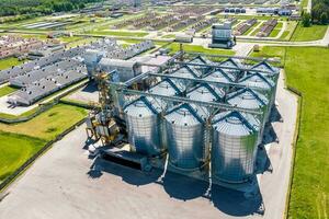 aerial panoramic view on agro-industrial complex with silos and grain drying line for drying cleaning and storage of cereal crops photo