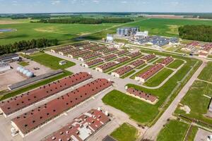 aerial panoramic view over silos and rows of barns, pigsties, chicken coops of huge agro-industrial livestock complex photo