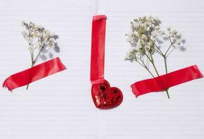 Empty white sheet of paper and gypsophilia flowers on a beige background, space for an inscription photo