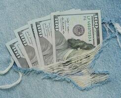 Paper American dollar bills on blue jeans photo