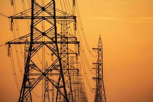 High voltage electric transmission tower. High voltage power lines on electric pylon against a sunset sky. Electrical infrastructure. Energy crisis. Electric power distribution. Energy distribution. photo