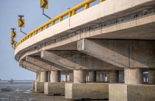 Structure of reinforced concrete bridge along the sea. Bottom view of concrete bridge. Concrete bridge engineering construction. Modern cement bridge with strong column architecture. Infrastructure. photo