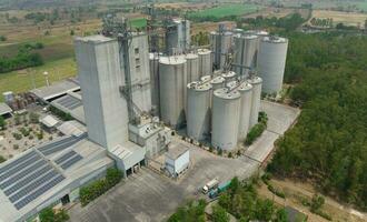 Aerial view of animal feed factory. Agricultural silos, grain storage silos, and solar panel on roofs of industrial plants. Industrial landscape. Agriculture industry. Factory with sustainable energy. photo