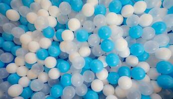 Blue and white plastic balls in ball pool at kids playground. Colorful plastic ball texture background. Many small colorful hollow plastic soft kids balls are in a ball pit. Play toy for kids. photo