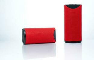 Wireless portable speaker isolated on white background. Red Digital portable speakers. Small sound music box speaker. Modern design mini portable Wireless loudspeaker. Digital wireless technology. photo
