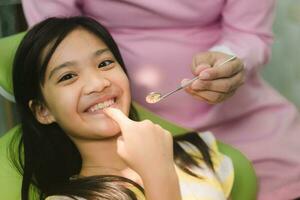 linda asain niña durante dental tratamiento a moderno clínica foto