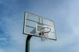 bajo ángulo ver de baloncesto anillo en cielo antecedentes. al aire libre baloncesto aro. foto