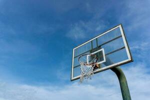 Low angle view of basketball ring on sky background. Outdoor basketball hoop. photo