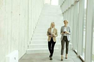 Business women walking in the office corridor photo