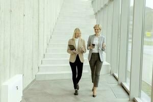 Business women walking in the office corridor photo