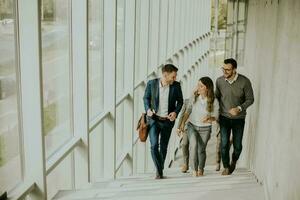 Group of corporate business professionals climbing at stairs in office corridor photo