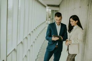 Young modern business people using digital tablet in the office corridor photo