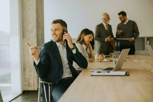 Young business man using mobile phone in the office photo