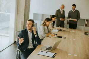 Young business man using mobile phone in the office photo