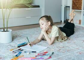 Child girl drawing with colorful pencils photo