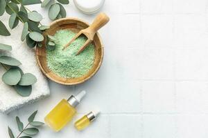 Soap, eucalyptus, towel, massage salt, aroma oil,  spa objects on white tile background. photo