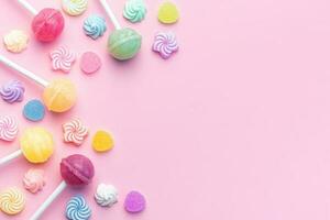 Sweet lollipops and candies on pink background photo