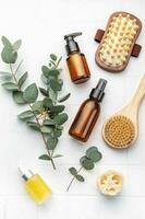 Spa treatment concept. natural spa cosmetics products with eucalyptus oil,, massage brush, eucalyptus leaf. photo