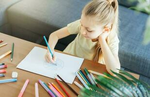 Child girl drawing with colorful pencils photo