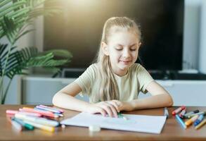 Child girl drawing with colorful pencils photo