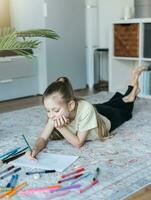 Child girl drawing with colorful pencils photo