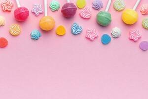 Sweet lollipops and candies on pink background photo