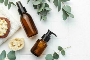 Spa treatment concept. natural spa cosmetics products with eucalyptus oil, massage brush, eucalyptus leaf. photo
