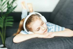 Cute little girl listening to music in headphones photo