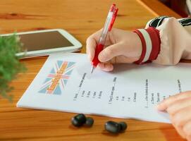 English test with red pen and tab on wooden desk photo